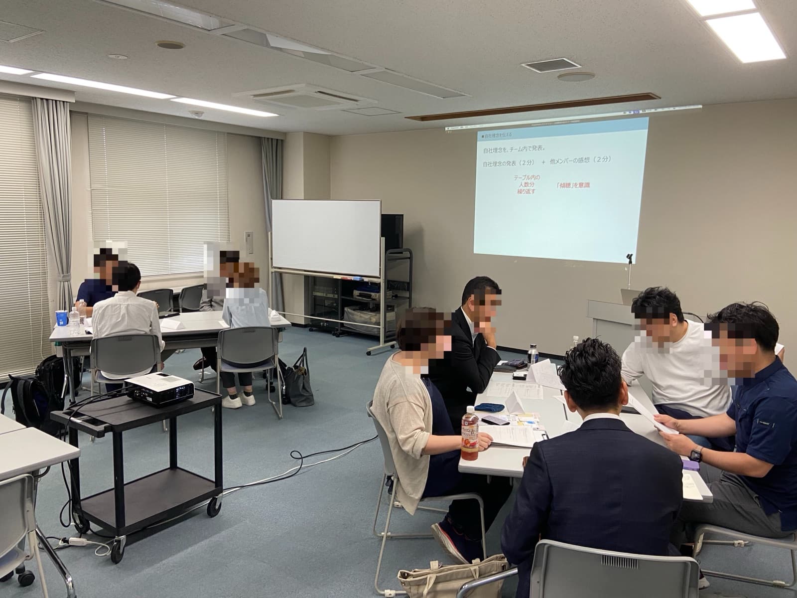 企業理念作成セミナーで、参加者がグループに分かれて自社理念を発表し合っている様子