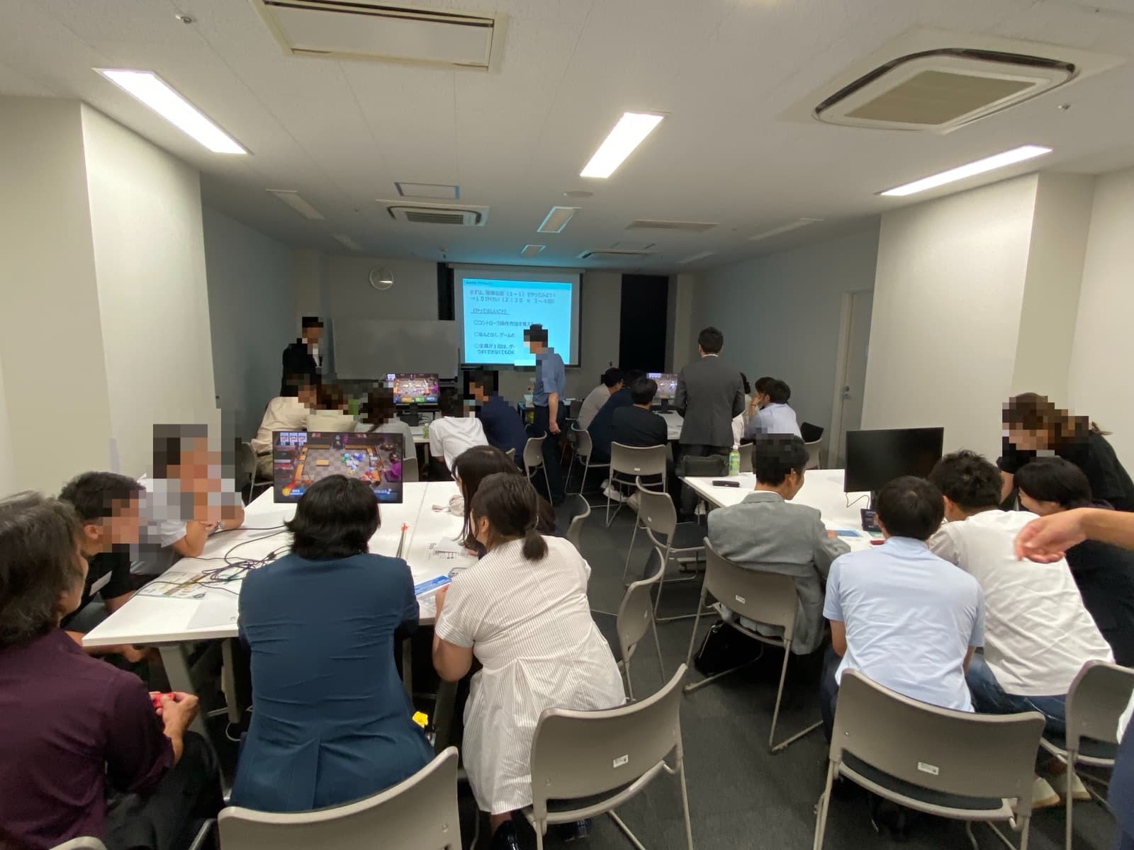 テレビゲームを活用したコミュニケーション研修で、参加者がチームに分かれてゲームに取り組んでいる様子